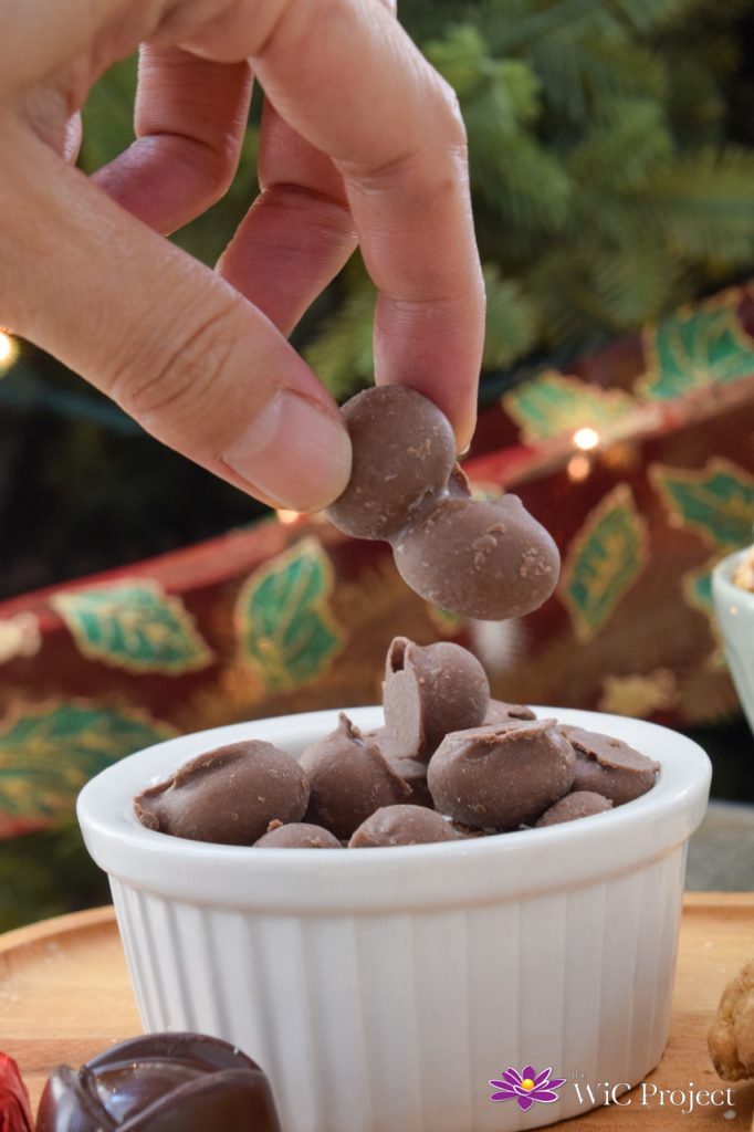 Hand reaching to grab chocolate dipped peanuts